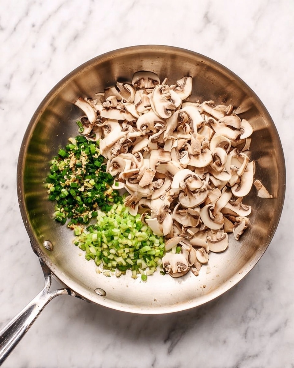 A shiny metal pan sits on a white marbled surface, filled with two main layers of food. On the right side of the pan, there are many thinly sliced mushrooms, light beige with brown edges, piled loosely. On the left side, there are small pieces of bright green chopped scallions mixed with minced garlic, spread out in a small patch. The pan handle extends out to the left, resting on the marbled surface. photo taken with an iphone --ar 4:5 --v 7