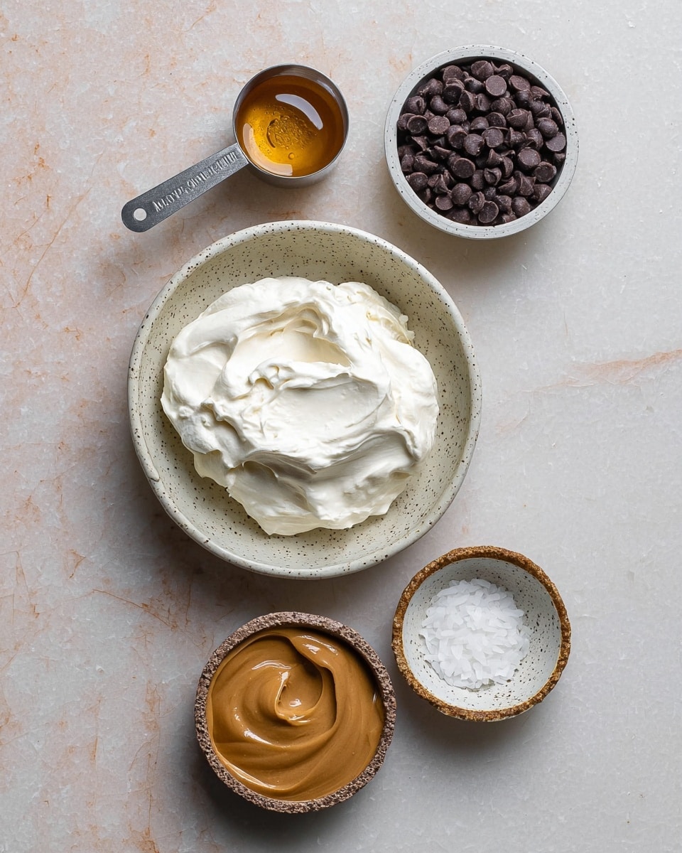 A top view of five small white speckled bowls and a metal measuring cup with creamy peanut butter, arranged neatly on a white marbled surface. The largest bowl at the center holds smooth, fluffy white cream. Above it, a smaller bowl contains dark chocolate chips, while to the right a very small white bowl has a small dollop of solid white coconut oil. Below, a tiny rustic bowl with a rough texture holds golden honey. To the left side, the metal measuring cup is filled with smooth peanut butter, completing the assortment of ingredients in an organized layout photo taken with an iphone --ar 4:5 --v 7