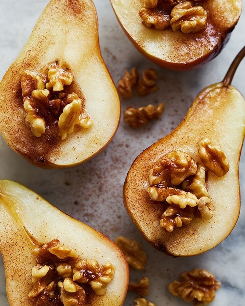 The image shows one pear cut in half, placed on a white marbled surface. The pear's inside is light cream with a dusting of brown cinnamon powder on top. In the hollow center of the pear half, there are walnut pieces. A metal spoon is held above the pear, pouring golden honey gently onto the walnuts and pear inside. The background shows a blurry part of the second half of the pear. The photo taken with an iphone --ar 4:5 --v 7