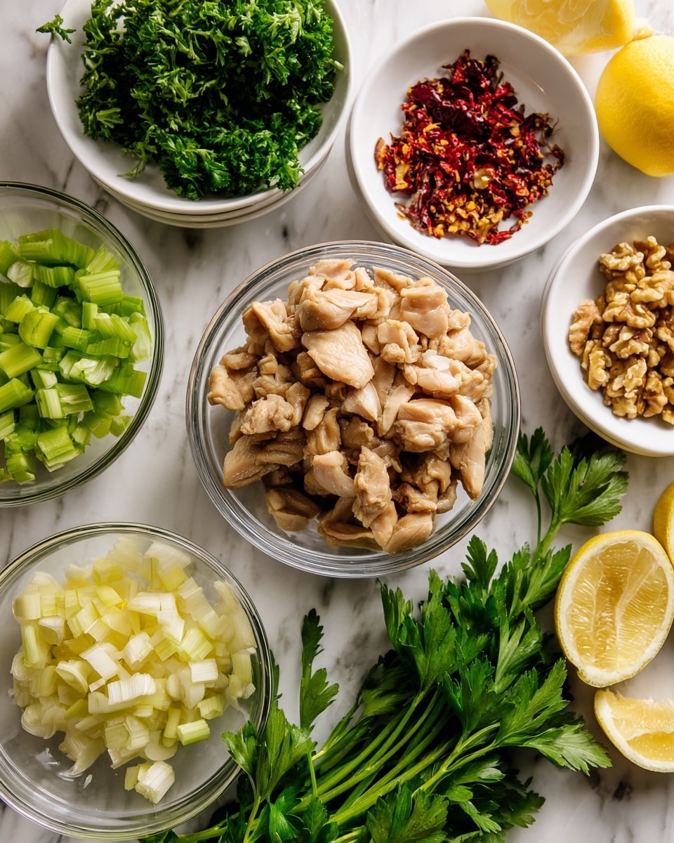The image shows several white bowls and a glass bowl arranged neatly on a white marbled surface. In the center, there is a clear glass bowl filled with cooked chicken pieces in light beige and tan colors. Surrounding it are six white bowls containing different ingredients: finely chopped green celery, sliced pale yellow ginger, small chopped white onions, crushed yellowish walnuts, and red chili flakes. Two lemon halves with bright yellow skin are placed near the bowls, along with a bunch of fresh green parsley with long stems lying flat. The overall colors range from warm chicken tones to vibrant greens and yellows. Photo taken with an iphone --ar 4:5 --v 7