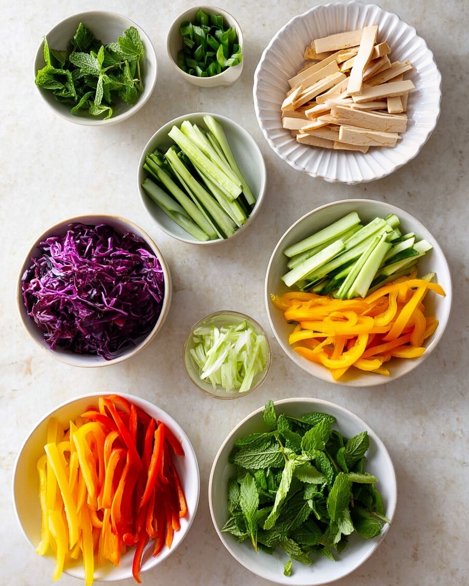 The image shows seven white bowls and plates arranged on a white marbled surface, each holding different fresh vegetable layers. From top right in a fluted white bowl, there are light beige thin strips with a darker brown outer edge, resembling tofu or a similar item. Below it, in a round white bowl, there are sticks of green cucumber with dark skin. Adjacent is a bowl full of long, leafy green pieces that seem like chopped lettuce. Next to the lettuce, a bowl contains thin, shredded purple cabbage. At bottom left, a white bowl holds vibrant yellow and red bell pepper strips layered one on top of the other. Beside this bowl, a colander contains bright orange carrot sticks. In the middle left, a white plate holds pale and dark green sliced scallions. In the top left corner, a small white bowl holds fresh green mint leaves. The colors are fresh and vibrant, laid out clearly on the white marbled surface. Photo taken with an iphone --ar 4:5 --v 7
