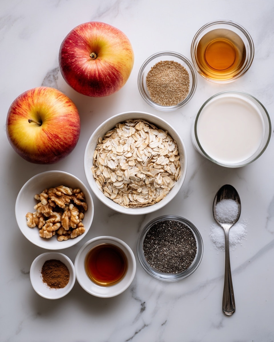 The image shows ingredients laid out on a white marbled surface, including two whole sweet apples with red and yellow skin positioned on the left. A white bowl filled with light brown rolled oats sits near the center. Around the bowl, there are small white bowls containing chopped walnuts, black chia seeds, and a mix of ground cinnamon and ground nutmeg. Clear small glass bowls hold dark brown maple syrup and light brown vanilla extract. A clear glass cup nearby has frothy non-dairy milk. A metal spoon with white salt is placed at the bottom right. The overall setup is neat and organized, ready for cooking, photo taken with an iphone --ar 4:5 --v 7