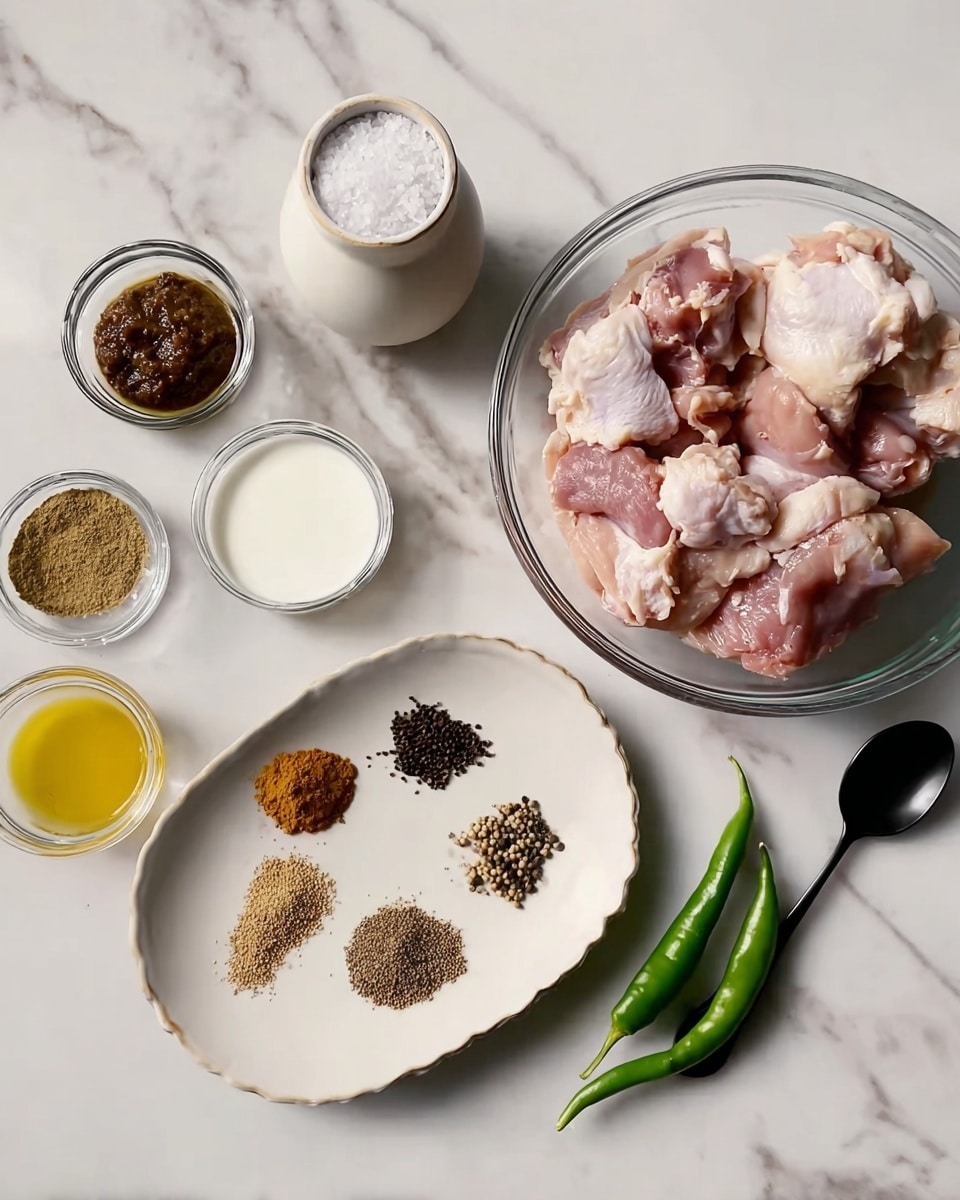 The image shows a clear glass bowl filled with raw chicken pieces placed on the right side of a white marbled surface. To the left of the bowl, there is a white oval plate holding six different small piles of whole spices in a circular pattern, featuring shades of black, brown, and light tan. Surrounding the plate and bowl are small glass and ceramic bowls with various ingredients: a dark brown paste in one, a white creamy mixture in another, a yellow sauce in a third, and a small brown powder heap in another. Two whole green chilies lie next to the plate. A white ceramic jar filled with white granulated substance and a black spoon stands on the far right. Everything rests on the white marbled surface. photo taken with an iphone --ar 4:5 --v 7